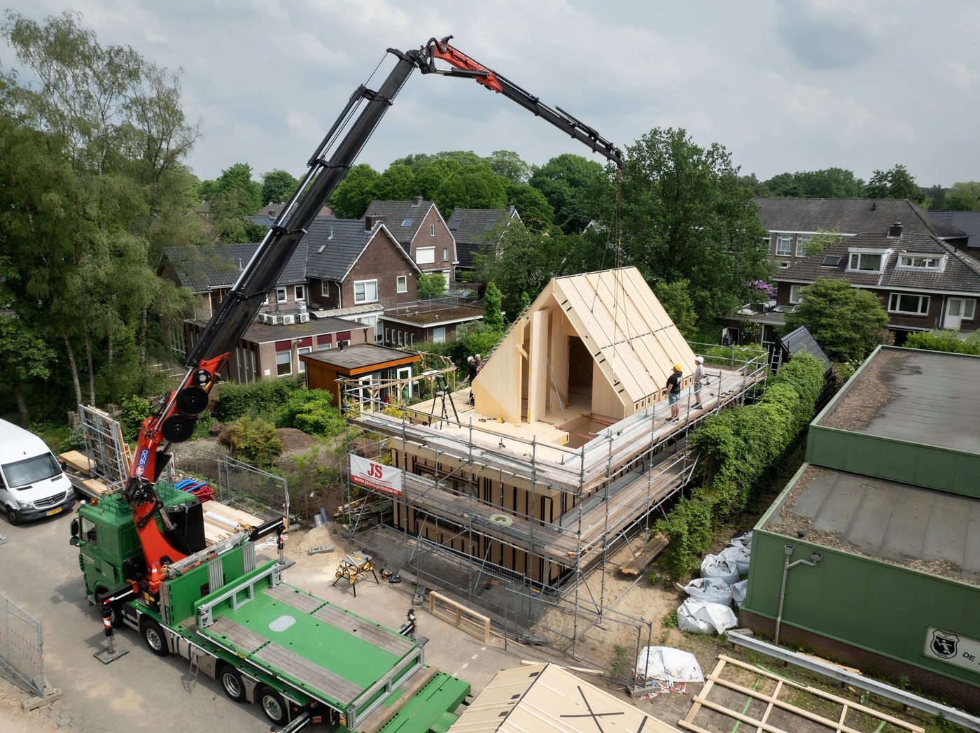 Houten dakelement wordt met een kraan op zijn plek gehesen